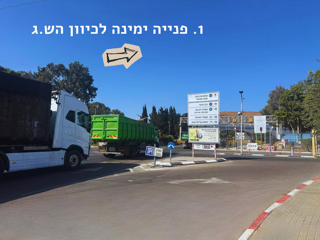 משאית לבנה וירוקה בצומת עם הנחיה לפנות ימינה לכיוון הש.ג