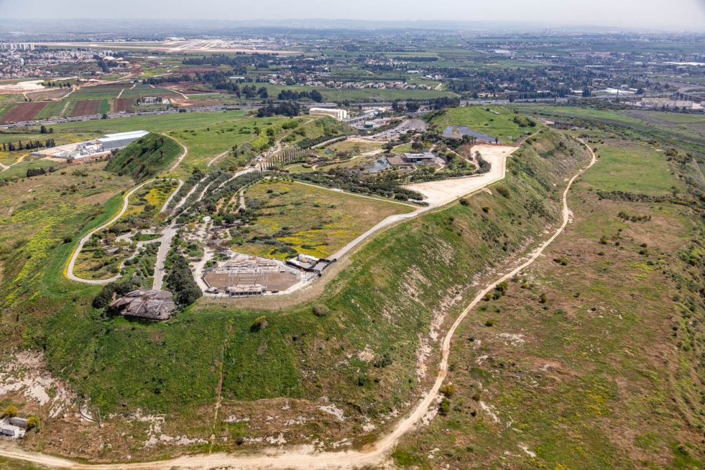 מבט אווירי על גבעה ירוקה עם שבילי הליכה ומבנים