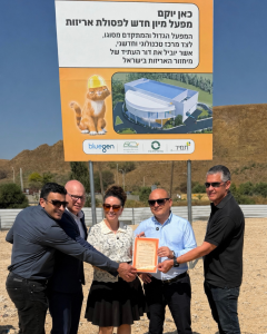 בכירי איגוד ערים דן לתברואה, ק.מ.מ, תמיר והמשרד להגנת הסביבה במעמד הנחת אבן פינה למפעל האריזות ליד שלט המבשר על כך